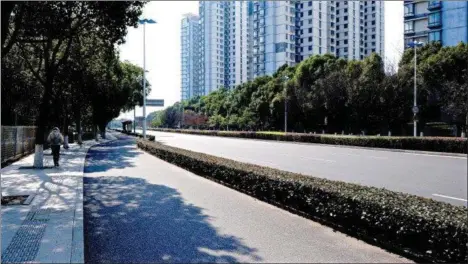  ??  ?? Kathy Kane walking along an empty road in Suzhou.