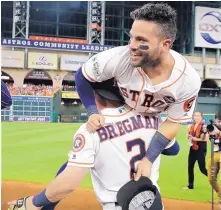  ?? DAVID J. PHILLIP/ASSOCIATED PRESS ?? Albuquerqu­e Academy alumnus Alex Bregman (2) hoists Houston teammate Jose Altuve into the air after the Astros’ win Saturday.