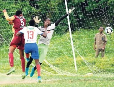  ?? PHOTO EDITOR RICARDO MAKYN/MULTIMEDIA ?? Wolmer’s Boys’ Clayon Haynes (left) shakes off Holy Trinity defender Dwayne Green (centre) and puts a header beyond goalkeeper Stephen Lindsay to score the match winner during their Group G ISSA/Digicel Manning Cup clash at the Bell Chung Oval, yesterday.