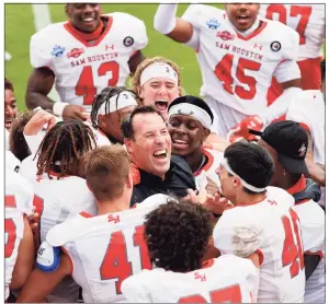  ?? Michael Ainsworth / Associated Press ?? Sam Houston State head coach K.C. Keeler, center, is swarmed by his team after they defeated South Dakota State in the NCAA college FCS Football Championsh­ip in Frisco, Texas, on May 16.