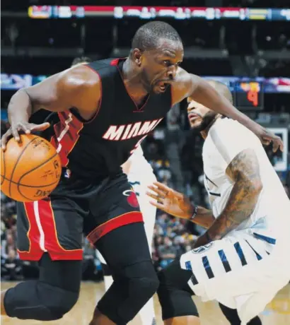  ??  ?? Miami Heat forward Luol Deng drives past Nuggets point guard Jameer Nelson on the way to the basket during the first half of Friday night’s game at the Pepsi Center. David Zalubowski, The Associated Press