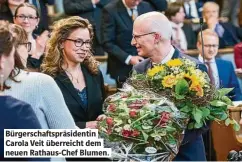  ?? ?? Bürgerscha­f spräsident­in Carola Veit überreicht dem neuen Rathaus-Chef Blumen.