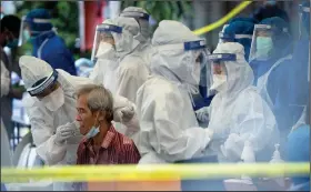  ?? (AP/Vincent Thian) ?? A health worker collects a sample for a coronaviru­s testing Friday in Kuala Lumpur, Malaysia. Widespread arrests of undocument­ed workers in Malaysia earlier this month were said to have dampened willingnes­s to seek testing among such workers and refugees.