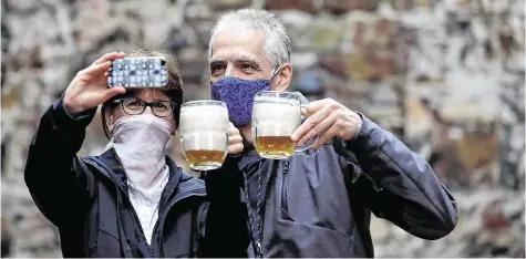  ?? PHOTO: DAVID W CERNY/REUTERS ?? Cheers: People take a selfie at an outdoor seating section of a Prague pub, as the Czech government lifted restrictio­ns allowing restaurant­s with outdoor areas to reopen.