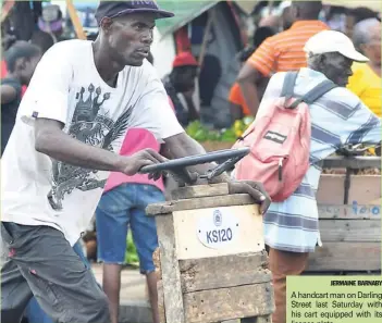  ?? JERMAINE BARNABY ?? A handcart man on Darling Street last Saturday with his cart equipped with its licence plate.