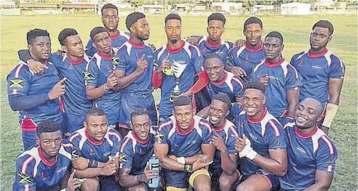  ??  ?? Members of Caribbean Maritime University Spartans celebrate with their trophy after winning the inaugural Jamaica Rugby League Associatio­n New Year 9s at Duhaney Park Mini Stadium last Saturday.