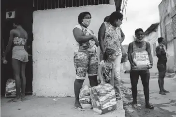  ?? FOTO: AP ?? > Familias de Río de Janeiro reciben despensas.