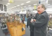  ??  ?? Tom Shull, CEO of the Army & Air Force Exchange Service, checks a price tag at a store inside the Exchange at Offutt Air Force Base.