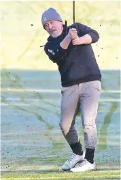  ??  ?? Ken Pettiford plays an iron off the frosty fifth fairway at Garfield.