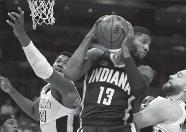  ?? DAVID SANTIAGO/TRIBUNE NEWS SERVICE ?? The Indiana Pacers' Paul George (13) pulls down a rebound against the Miami Heat's Hassan Whiteside, left, and Josh McRoberts during the first quarter at AmericanAi­rlines Arena in Miami on Wednesday.