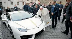  ??  ?? Lamborghin­i chief executive Stefano Domenicali watches as the Pope vandalises a parked car. Actually, he’s more than doubling its value.