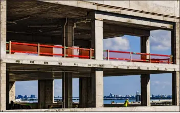  ?? SCOTT MCINTYRE — THE NEW YORK TIMES ?? A constructi­on worker surveys Biscayne Bay and downtown Miami from a new high rise condo in Miami on Oct. 27. Hammered by supply chain woes and fluctuatio­ns in demand, builders have learned to become more adept managing challenges.