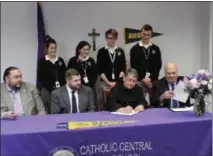  ?? PHOTO PROVIDED ?? Catholic Central High School students look on as Siena College President signs the formal agreement of the “Crusader to Saint” Academic Partnershi­p Program. Seated left to right are Giovanni Virgiglio, Superinten­dent of Schools; Ridge Harris, Chairman of the Board of Trustees of CCHS; Br. Ed Coughlin, President of Siena College; Christophe­r Signor, Principal of Catholic Central.