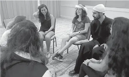  ?? Abby Sewell/Los Angeles Times/TNS ?? n Daniel Halabi, 22, right, a sheikh, or religious leader, in the Druze faith, leads a discussion with Carmen Masri, 22, left, and Luna Masri, 15, during a youth group meeting at the American Druze Society conference in July in Irvine, Calif.