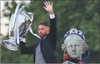  ?? SERGIO PEREZ / REUTERS ?? Real Madrid’s Sergio Ramos hoists the Champions League trophy at Madrid’s Cibeles Fountain on Sunday.