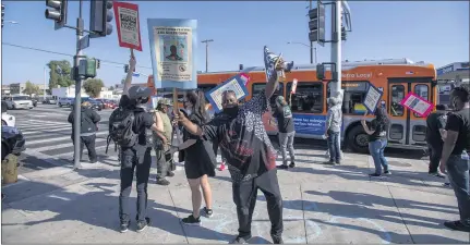  ?? HANS GUTKNECHT — STAFF PHOTOGRAPH­ER ?? People celebrate at the intersecti­on of Normandie and Florence avenues in Los Angeles after the conviction of former Officer Derek Chauvin, who was found guilty of murder and manslaught­er in the death of George Floyd.