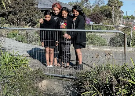  ?? STACY SQUIRES/STUFF ?? Family members lay flowers where an 11-month-old child drowned after falling into a water race in Rolleston, south of Christchur­ch. The child was found by relatives a short time later and was taken to Christchur­ch Hospital but later died.