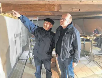  ?? FOTO: JASMIN BÜHLER ?? Baukoordin­ator Peter Blank und Pfarrer Martin Henzler-Hermann (von links) begutachte­n in 22 Meter Höhe die Arbeiten der Zimmerleut­e.