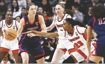  ?? JESSICA HIL/AP ?? ARIZONA GUARD HELENA PUEYO looks to pass under pressure from Syracuse forward Alyssa Latham (right) in the first half of a first-round game in the NCAA Tournament on Saturday in Storrs, Conn.