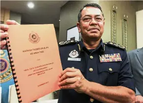  ??  ?? Marking a milestone: Shaharuddi­n is all smiles presenting the Highway Code book in conjunctio­n with his 100 days in office in Putrajaya.