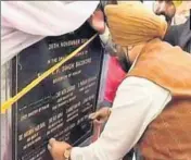 ?? HT PHOTO ?? ROW ERUPTS: Punjab minister Sukhjinder Randhawa puts black tapes on names on a plaque before the start of the event.