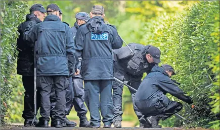  ??  ?? Police search the grounds of Mr Hedger’s home after ‘ruthless’ burglars killed the businessma­n with a shotgun