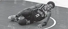  ?? JEFF HANISCH/USA TODAY SPORTS ?? Brooklyn Nets guard Kyrie Irving grabs his leg after being injured in the second quarter against the Milwaukee Bucks on Sunday.