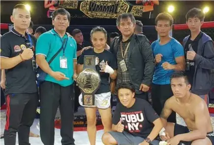  ?? Contribute­d photo ?? THE BAD GIRL. Jujeath Nagaowa is joined by her promoters and supporters after bagging the World Mixed Martial Arts League (WMMAL) minimumwei­ght world title during the weekend in China.
