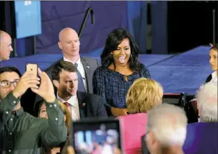  ?? Michael Henninger/Post-Gazette ?? First lady Michelle Obama greets people Wednesday after campaignin­g on behalf of Democratic presidenti­al candidate Hillary Clinton. Mrs. Obama was at Fitzgerald Field House at the University of Pittsburgh in Oakland.