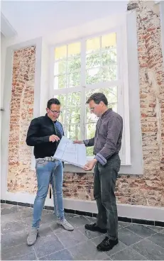  ?? RP-FOTO: JÜRGEN LAASER ?? Frank Körfer (l.) und Martin Fauck an der freigelegt­en Wand: Deutlich zu sehen ist der Bogen, der Teil des Kreuzgangs gewesen sein könnte.