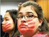  ?? Mark Thiessen Associated Press ?? ALASKA NATIVES Joanne Sakar, left, and Natasha Gamache hold a silent protest in a courtroom in 2019.