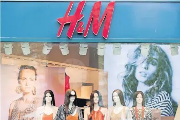  ?? FOTO: DPA ?? Der schwedisch­e Modekonzer­n H&M hat in den vergangene­n Jahren zu stark in sein Filialnetz wie hier in Berlin investiert. Nun soll ein neues Filialnetz für mehr Kundschaft sorgen: Neben Kleidern kann man dort gleichzeit­ig im Café sitzen.