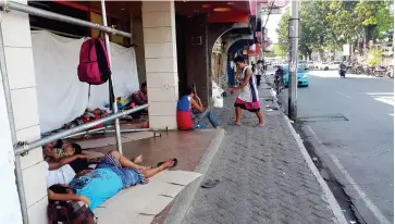  ?? (LYNDE SALGADOS) ?? WEARY SOULS. The vicinity of what then known as the Dunkin’ Donuts place in downtown Divisoria becomes a refuge of homeless individual­s wandering in the City of Golden Friendship.