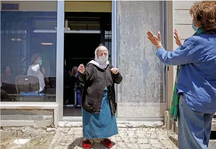  ?? AFP ?? 20% of Saudi and UAE respondent­s said they would feel comfortabl­e visiting restaurant­s, malls and hotels if a medicine to treat the coronaviru­s were made widely available.
A health volunteer dances with an elderly resident during her visit to a retirement home at Ain Wazein, southeast of Beirut, amid confinemen­t due to the COVID-19 pandemic.