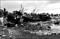  ?? LI JIANSHU / FOR CHINA DAILY ?? Left: Fishing boats litter the shore near Qinglyu Road in Zhuhai, Guangdong province, on Wednesday, after being pushed by the typhoon and tides.