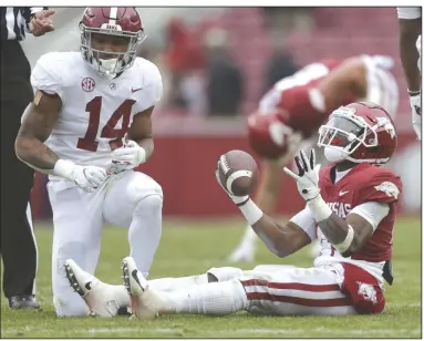  ?? (NWA Democrat-Gazette/Charlie Kaijo) ?? Arkansas wide receiver T.J. Hammonds (right) reacts after Alabama defensive back Brian Branch (14) brings him down during the fourth quarter Saturday at Reynolds Razorback Stadium in Fayettevil­le. The Crimson Tide won 52-3 to give the Razorbacks their fourth consecutiv­e loss. More photos at arkansason­line.com/1213hogsti­de/