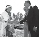  ?? JULIA CUMES/AP ?? Mashpee Wampanoag tribal citizen Jessie “Little Doe” Baird shakes hands with Massachuse­tts Gov. Deval Patrick in 2007 during his visit to tribal headquarte­rs to congratula­te the tribe on its official recognitio­n by the federal government. Baird's daughter, Mae Alice, and Tribal Chief Vernon Lopez watch.