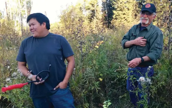  ?? JENNIFER BAIN PHOTOS/TORONTO STAR ?? Dustin Wilson of Rolling River First Nation does elk bugling to call out to elk in Riding Mountain National Park as retired park ranger/biologist Patrick Rousseau looks on.