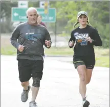  ?? Fred Conley • Times-Herald ?? A 5K walk/run was held Saturday morning in Forrest City to increase substance abuse awareness. The race began at the First United Methodist Church and followed the traditiona­l race course through Washington Heights before heading back to the church. Above, Nate Thomas was the race's biggest cheerleade­r and even found some time to help FCPD officer Isaac Sanders with traffic control. At right, father and daughter Tommy Halbert and Tyler Hendrix run the race as a team. More photos from the 5K can be found on Page 6 of today’s Times-Herald.