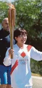  ?? REUTERS PIC ?? Japanese former marathon runner Noguchi Mizuki poses with the torch during the opening of the Olympic flame torch relay for the Tokyo Olympics on Thursday.