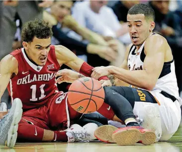  ?? [AP PHOTO] ?? Oklahoma guard Trae Young goes to the floor for a loose ball with Oklahoma State guard Jeffrey Carroll during the first half Wednesday.