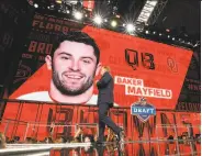  ?? Ronald Martinez / Getty Images ?? Commission­er Roger Goodell walks past a video board with an image of top pick Baker Mayfield.