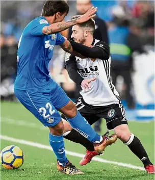  ?? — AFP ?? Outta my way: Getafe’s Damian Suarez (left) challengin­g Valencia’s Nacho Gil during the La Liga match on Sunday.