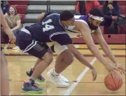  ?? GEORGE POHLY — MACOMB DAILY ?? D’Andre Scott (14) of Dakota and Tristan Nichols of De La Salle reach for a loose ball during the first quarter of a Division 1quarterfi­nal game at Detroit Renaissanc­e on Tuesday.