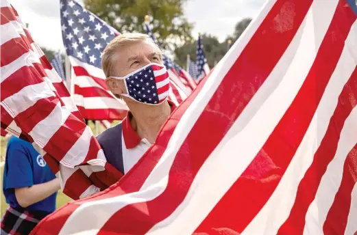  ??  ?? Jim Wilson sets up a display at the annual Field of Honor at San Gabriel Park on Nov. 6 in Georgetown, Texas.