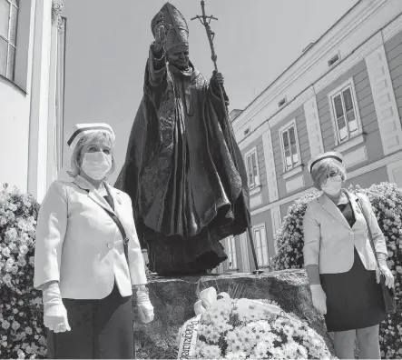  ?? REUTERS ?? Nurses in protective masks attend a ceremony to commemorat­e the 100th anniversar­y of the birth of late Pope John Paul II next to his monument in Wadowice, Poland on Monday.