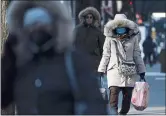  ?? SETH WENIG — THE ASSOCIATED PRESS ?? Pedestrian­s wear heavy coats against the cold in New York on Tuesday. A mass of arctic air swept into the Northeast, bringing bone-chilling temperatur­es.
