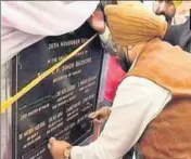  ??  ?? ROW ERUPTS: Punjab minister Sukhjinder Randhawa puts black tapes on names on a plaque before the start of the event. HT PHOTO