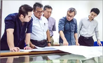  ??  ?? Mohd Fadzil (second left) takes a closer look at plans for the sports facility. BYG Architectu­re senior partner Michael Ong is at fourth left.