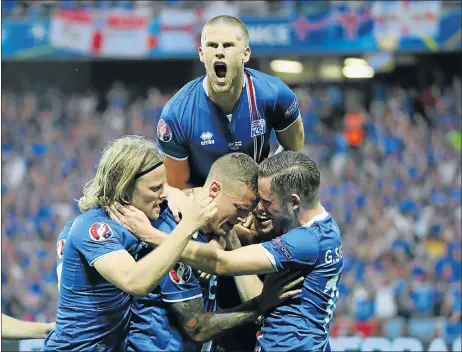  ?? Picture: EPA ?? GIANT KILLERS: Iceland’s Ragnar Sigurdsson, centre, celebrates with teammates after scoring the first goal against England on Monday in Nice, France.